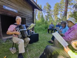 Kari Keurulainen säestää yhteislaulua museoriihessä